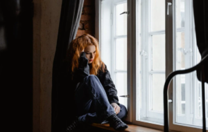 γυναίκα στο παράθυρο, κρατάει το κεφάλι της