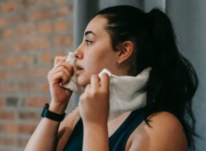 Γυναίκα σκουπίζει τον ιδρώτα της με πετσέτα