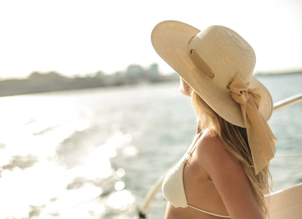 Γυναίκα απολαμβάνει τον ήλιο κοντά στη θάλασσα