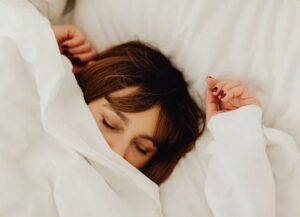 Γυναίκα κοιμάται σκεπασμένη με λευκό σεντόνι