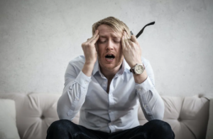 Άνδρας πονάει και πιάνει το κεφάλι του