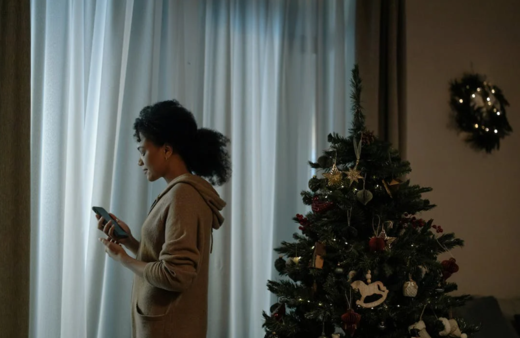 Γυναίκα μελαγχολική δίπλα στο χριστουγεννιάτικο δέντρο